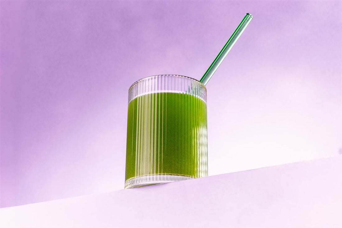 Ginger, cherries and a Wild Berry stick of 01. Bowel + Bloat beside a glass of green juice